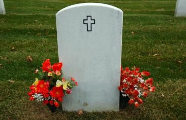 Gravestone with red flowers each side.